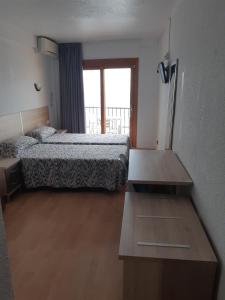 a hotel room with two beds and a table at Hotel Condestable in Benidorm