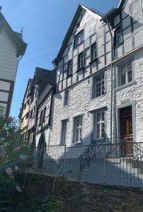 ein großes weißes Gebäude mit einem Zaun davor in der Unterkunft Manoir -1654- historisch schlafen in Monschaus Altstadt in Monschau