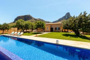 ein Schwimmbad vor einem Haus mit Bergen in der Unterkunft Finca can Jaumi By homevillas360 in Artá