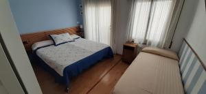 アレニス・デ・マルにあるHostal La Llunaの小さなベッドルーム(ベッド1台、ソファ付)