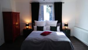 ein Schlafzimmer mit einem großen Bett mit Kissen und einem Fenster in der Unterkunft Manoir -1654- historisch schlafen in Monschaus Altstadt in Monschau