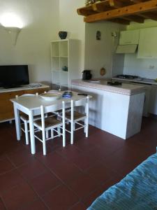 a kitchen with a white table and chairs and a counter at Visit San Teodoro in San Teodoro +9 photos