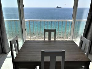 een tafel en stoelen op een balkon met uitzicht op de oceaan bij Levante Trip - Family Apartments in Benidorm