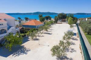 eine Aussicht über einen Strand mit Bäumen und Gebäuden in der Unterkunft Camping Sukošan Beach in Sukošan