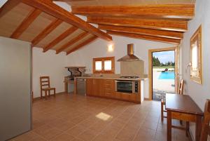 a large kitchen with a table and a dining room at Vinagrella in Llubí