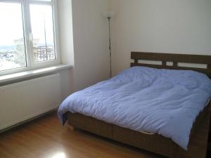 Bett in einem Zimmer mit 2 Fenstern in der Unterkunft Lydia in Vysoké Tatry