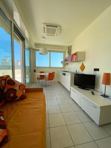 a kitchen and living room with a couch and a table at Hotel Avana in Riccione