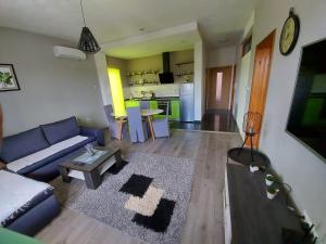 uma sala de estar com um sofá azul e uma mesa em Apartman Malkoc em Bihać