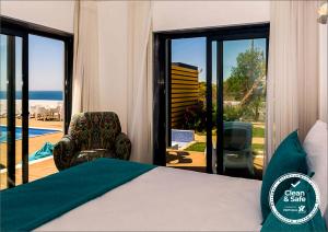Mareta Beach House - Boutique Residence في ساغريس: غرفة نوم مع سرير وإطلالة على المحيط