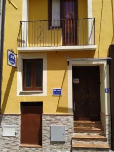 a yellow building with a balcony and two doors at B&B Arena Family in Fagnano Castello