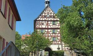 un edificio con una torre con un reloj. en Königin Victoria - Appartement mit Saunanutzung, en Burgbernheim