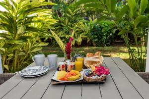 ein Tablett mit Obst und Saft auf dem Tisch in der Unterkunft Mon Choisy Beach R. in Mont Choisy