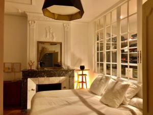een slaapkamer met een bed, een open haard en een spiegel bij 5 min place Stanislas. Appartement de caractère in Nancy