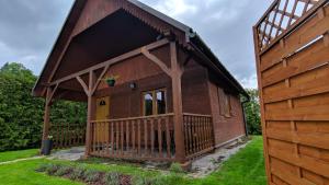 a log cabin with a porch and a yellow door at Domek pod Czulnią in Uherce Mineralne (7)