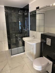 a bathroom with a toilet and a sink and a shower at Domek Maris in Międzyzdroje +5 photos