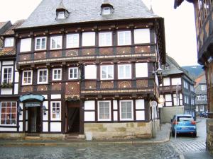 an old building on a street with a car parked in front at Altstadthotel Zur Börse in Goslar