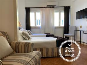 リスボンにあるDiscovery Apartment Expoのベッド2台とソファが備わるホテルルームです。