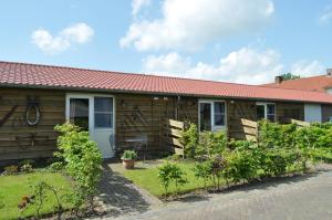 ein Holzhaus mit rotem Dach in der Unterkunft Weibos Bed & Breakfast in Schijndel