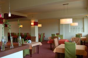 a dining room with tables and chairs and lights at Hotel Europa in Giżycko