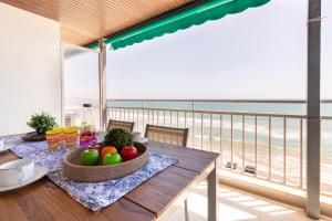 una mesa con un bol de fruta en el balcón en Homes & Go Bell Reco Confort II, en La Pineda