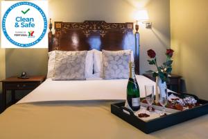 a hotel room with a bed with a bottle of champagne at Hotel Sao Jose in Porto