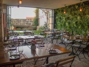 ポルトにあるALIBI by YoursPortoの木製のテーブルと椅子、植物のあるレストラン