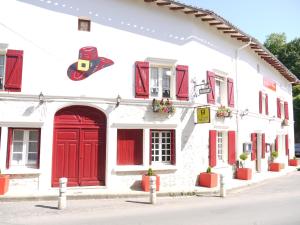 un edificio blanco con puertas rojas y ventanas rojas en Le Chapeau Rouge, en Lusignan