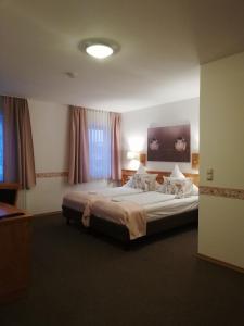 ein Schlafzimmer mit einem großen Bett in einem Zimmer in der Unterkunft Moosburger Hof in Moosburg