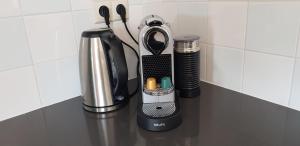 a kitchen counter with a coffee maker and a blender at The Blue House - Luxurious Waterfront Villa Zeewolde in Zeewolde