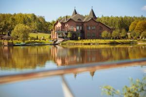 a large house sitting on top of a lake at Shepilska Relax Complex in Dovholuka