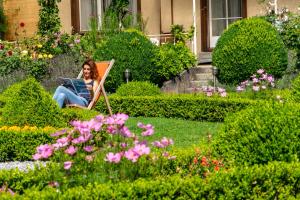 a person sitting in a garden with flowers at Alpenrose Hotel and Gardens in Wilderswil