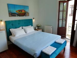 a bedroom with a large bed with a blue headboard at Casa Azul Hostel in Sintra