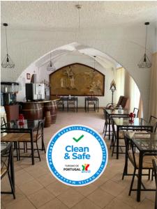 a restaurant with tables and chairs and a sign that says clean and safe at Hotel Nazareth in Lisbon
