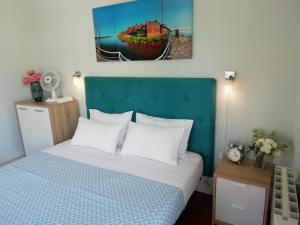 a bedroom with a bed and a painting on the wall at Casa Azul Hostel in Sintra