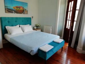 a bedroom with a blue bed with a blue headboard at Casa Azul Hostel in Sintra