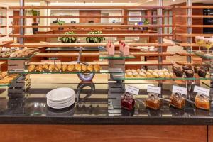 uma vitrine numa padaria com pastelaria e sobremesas em City Lodge Hotel Johannesburg Airport, Barbara Road em Kempton Park