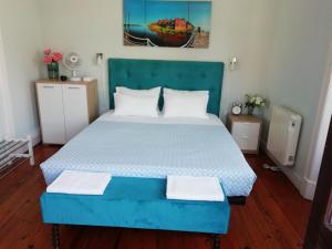 a bedroom with a blue bed with two white pillows at Casa Azul Hostel in Sintra
