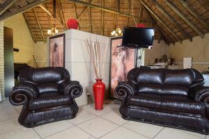 two leather chairs and a television in a room at Thabong Bed and Breakfast in Brakpan