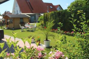 een tuin met een tafel, stoelen en bloemen bij Zimmer am Waldeck in Langenargen