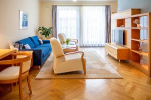 a living room with a blue couch and a table at Villa Marion in Luhačovice