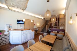 a restaurant with tables and chairs and a staircase at Cit'Hotel Normandy Hotel Pornichet La Baule in Pornichet
