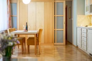 a dining room with a table and chairs and a kitchen at Villa Marion in Luhačovice