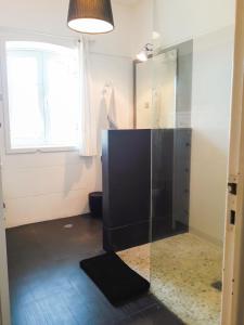 baño con ducha acristalada y ventana en Casa Surf en Sagres