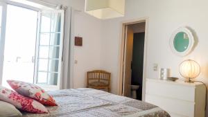 Habitación blanca con cama y ventana en Casa Surf, en Sagres