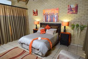 Brakpan的住宿－Thabong Bed and Breakfast，一间卧室配有带橙色带子的床