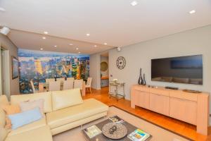 a living room with a couch and a flat screen tv at Apartamento Costa Do Sol in Funchal