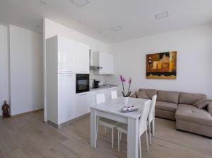 a white living room with a table and a couch at Le bougainvillea 1 in Corbetta