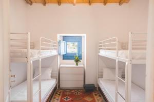 a room with white bunk beds and a window at Morgado do Quintão in Lagoa