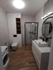 a bathroom with a shower and a sink and a toilet at Apartament Gardenia Klif 35 z widokiem na morze in Dziwnów