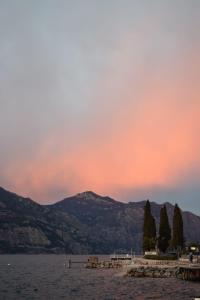 a sunset over a body of water with mountains at Albergo Al Pescatore in Brenzone sul Garda